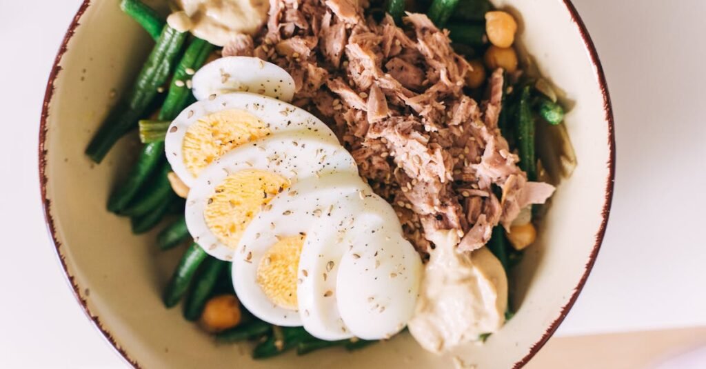 Delicious protein-packed bowl featuring tuna, boiled eggs, green beans, and hummus.